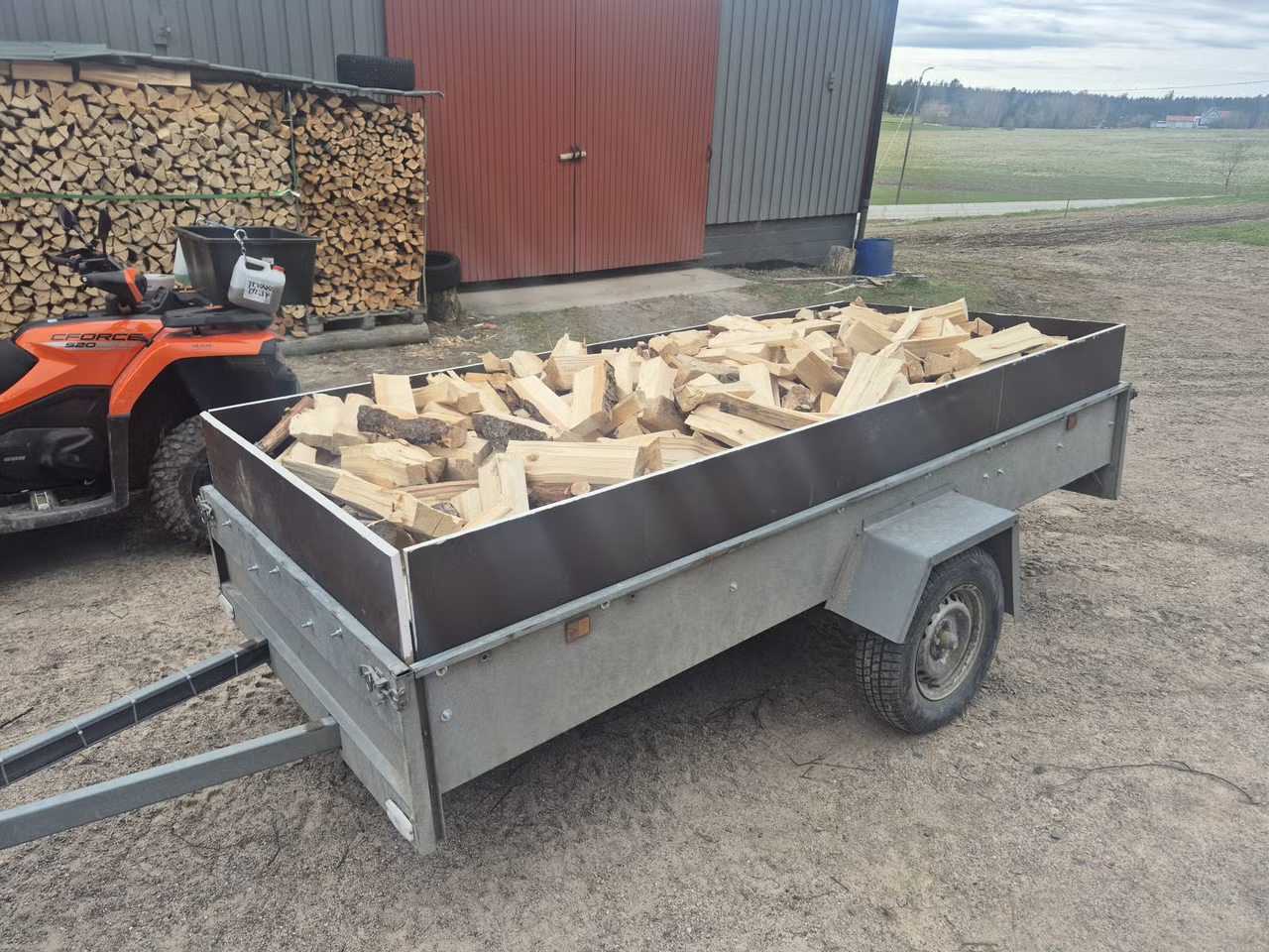Kuivaa polttopuuta peräkärryssä